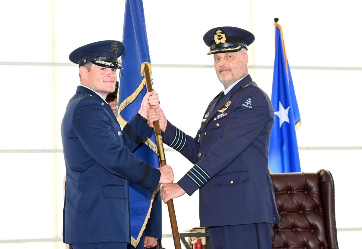 Brigadier General Scott Rowe handing the Heavy Airlift Wing flag to Colonel Harry Oostema. Photo: Jerry Lindbergh, HAW